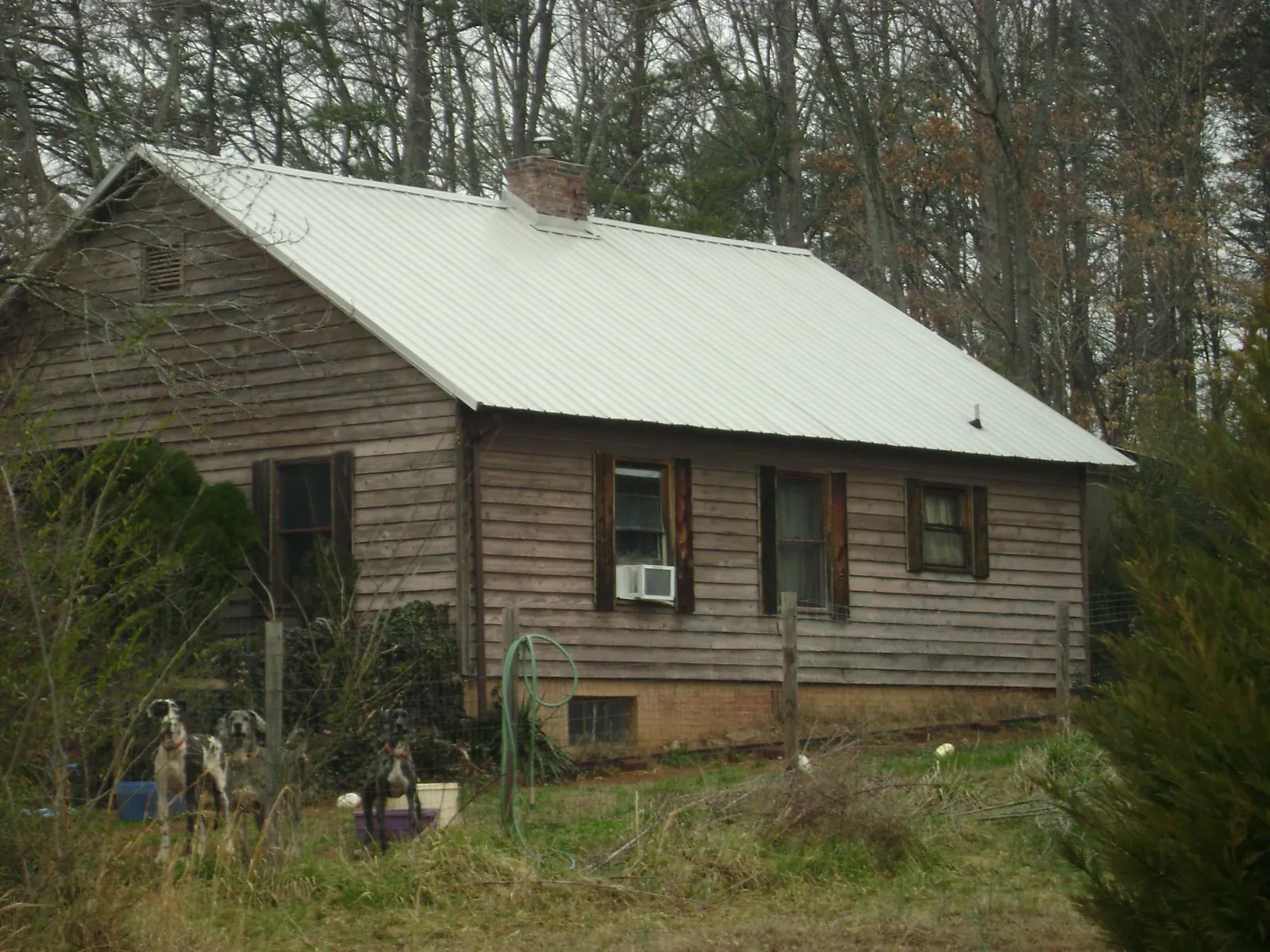 White metal roof on an old wood sided farmhouse, from a Metal Roof Installation job in Ellendale